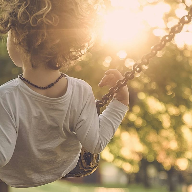 young boy swinging on swings